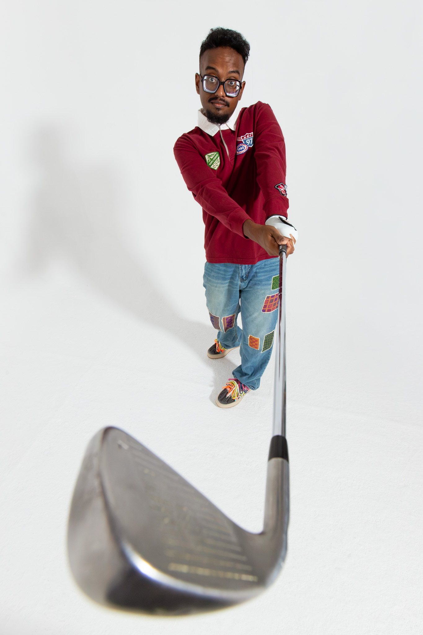 Holding a golf wedge out toward the camera